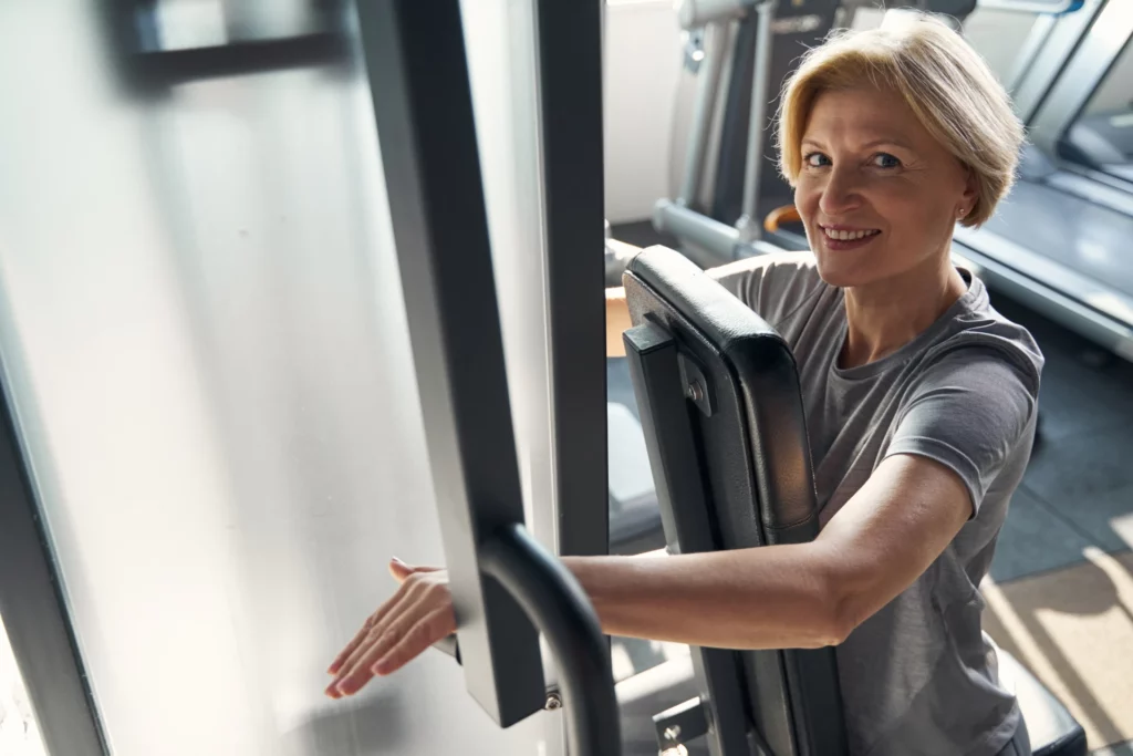 cheerful sporty woman doing exercise on gym equipm 2023 11 27 05 36 24 utc